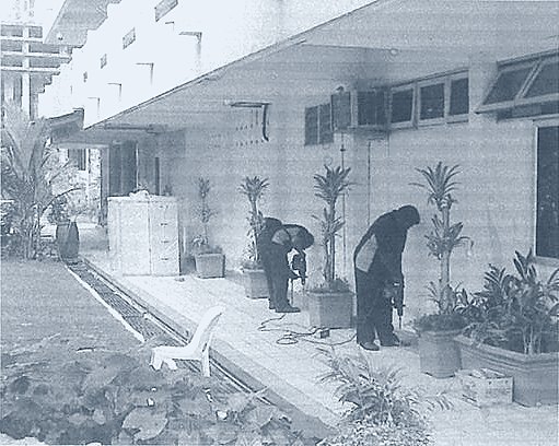 Two Helang Rampai technicians treating a building walkway